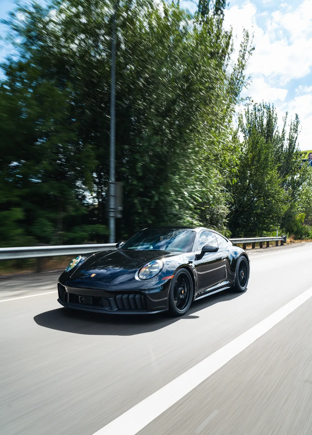 Black Porsche 911 on the highway in motion